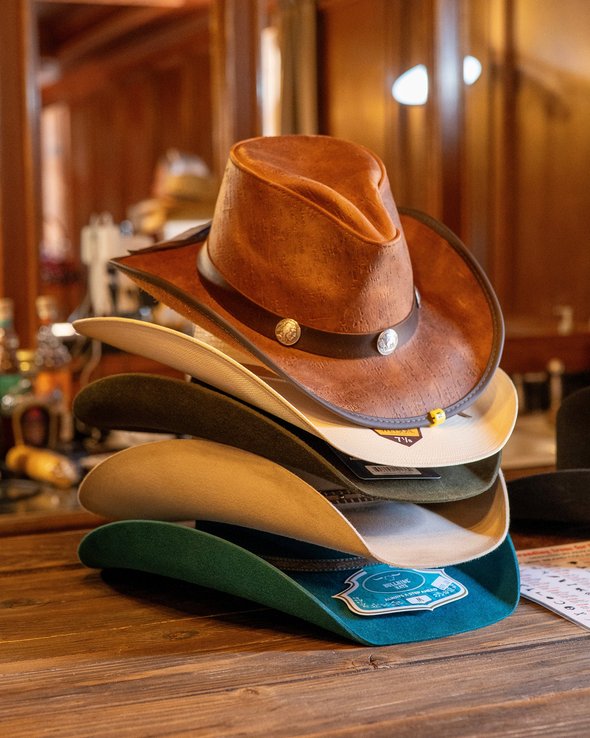 Stacked finished hats on wooden counter — Bar G interior